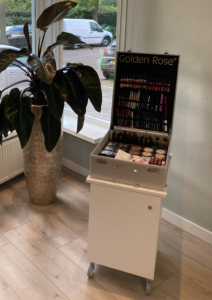 Olaplex fles vastgehouden door vrouwelijke handen, achtergrond blur