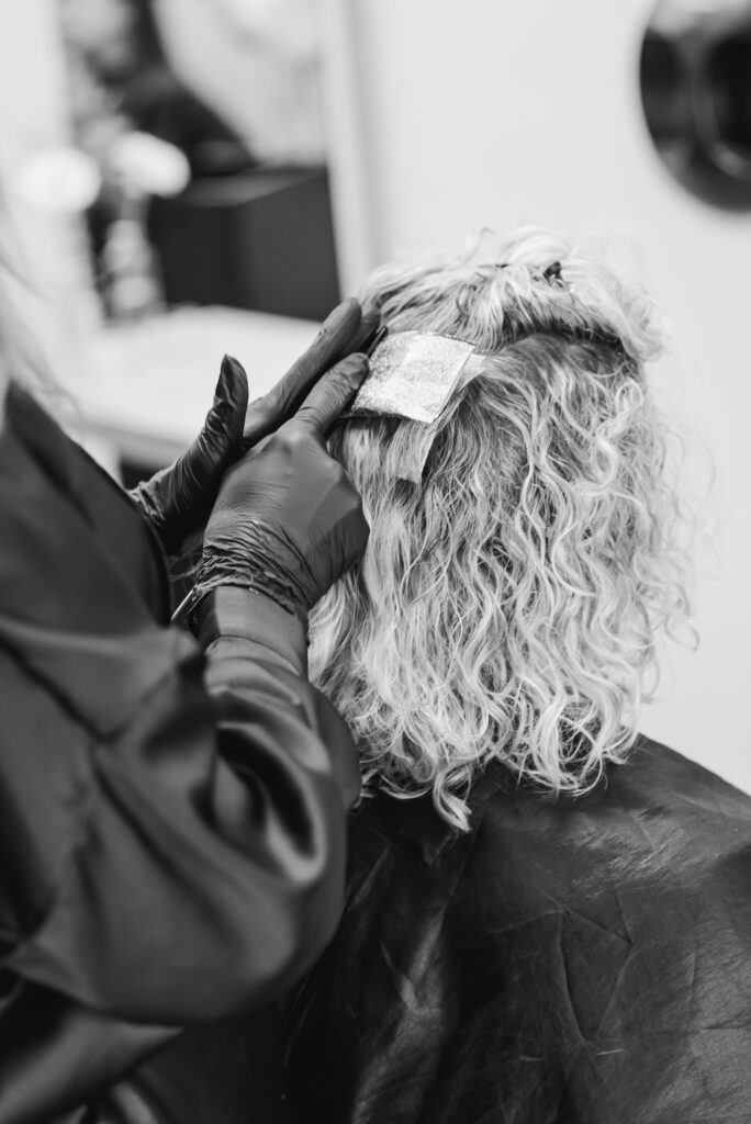 Foto in grijstinten van het zetten van lowlights in het haar