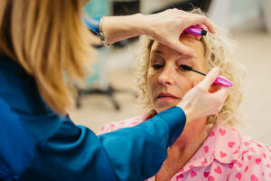 Mascara aanbrengen bij een vrouw met krullen